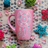 A Shimmery Pink hand painted mug with a dreamcatcher in white and colored in with (pink, blue and teal))