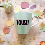 An Ivory hand painted mug with the name 