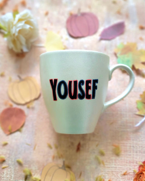 An Ivory hand painted mug with the name "yousef"