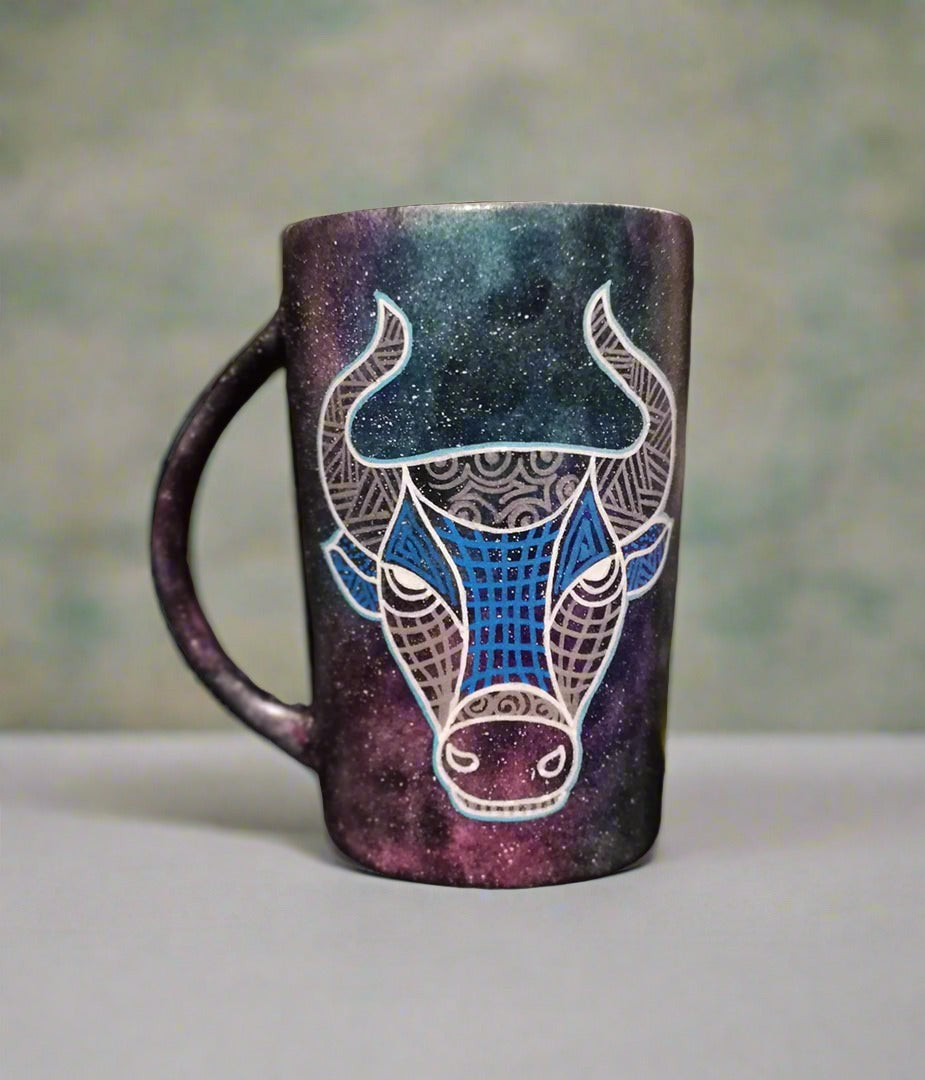 A hand-painted black galaxy mug with Taurus sign