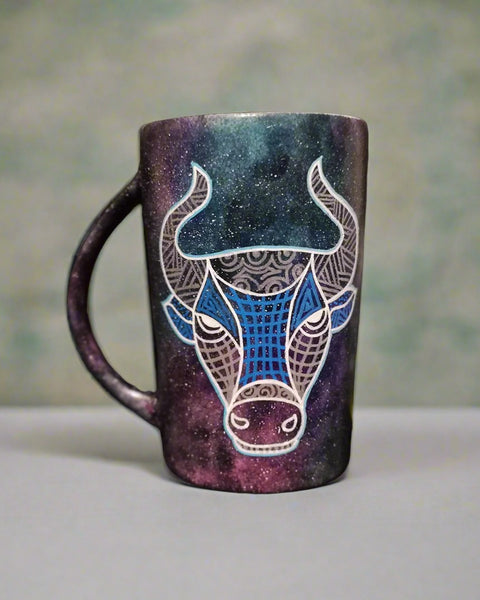 A hand-painted black galaxy mug with Taurus sign