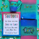 A Gift Set of a mug, notebook, wooden frame and card all painted in gradient colors of (pink-green-blue) . All with the name shereen