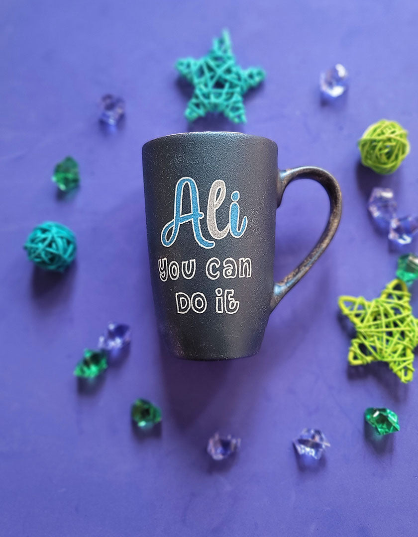 A shimmery blue hand painted mug with the sentence "ali, you can do it"