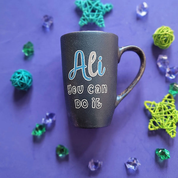 A shimmery blue hand painted mug with the sentence "ali, you can do it"