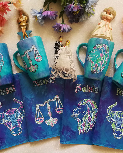 four hand painted gift sets of mug and matching card all in blue galaxy and each gift set has a zodiac and name (Taurus set has name pussi ), (Libra set has the name kanoz), (Leo Set has the name Maioia), (another Taurus set with the name nojy)