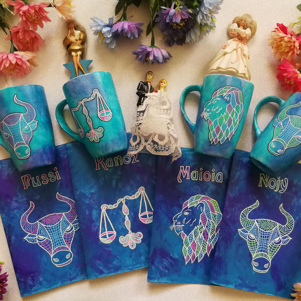 four hand painted gift sets of mug and matching card all in blue galaxy and each gift set has a zodiac and name (Taurus set has name pussi ), (Libra set has the name kanoz), (Leo Set has the name Maioia), (another Taurus set with the name nojy)