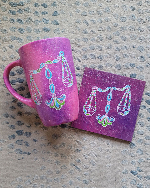 a pink galaxy hand painted mug and coaster with the libra sign